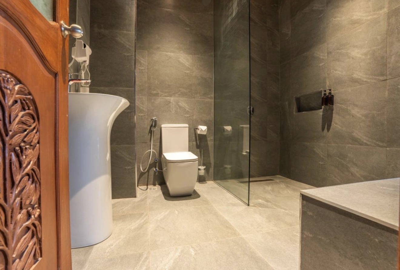 Stone-tiled bathroom with walk-in rain shower