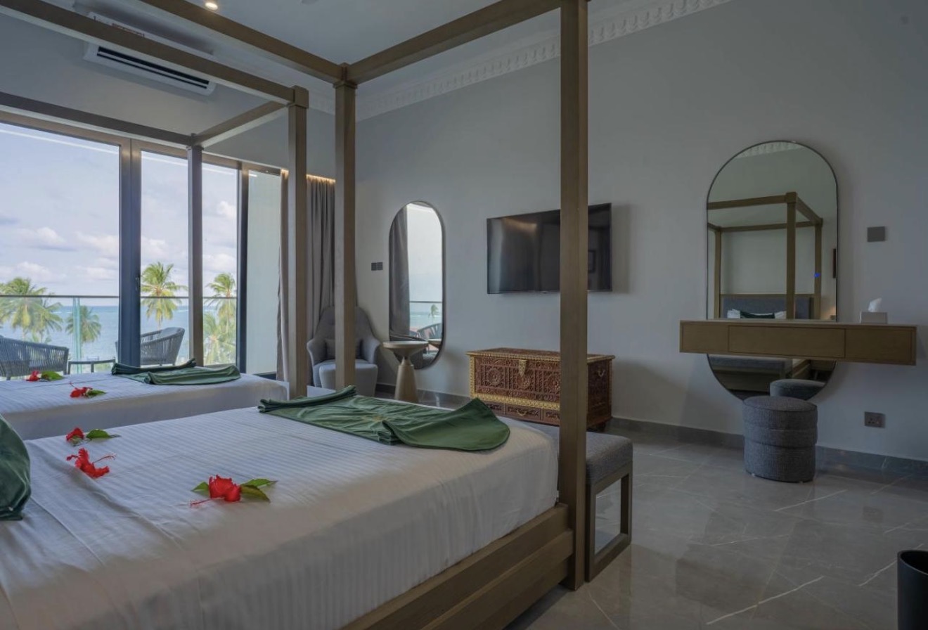 Spacious suite with four-poster beds and floor-to-ceiling ocean views