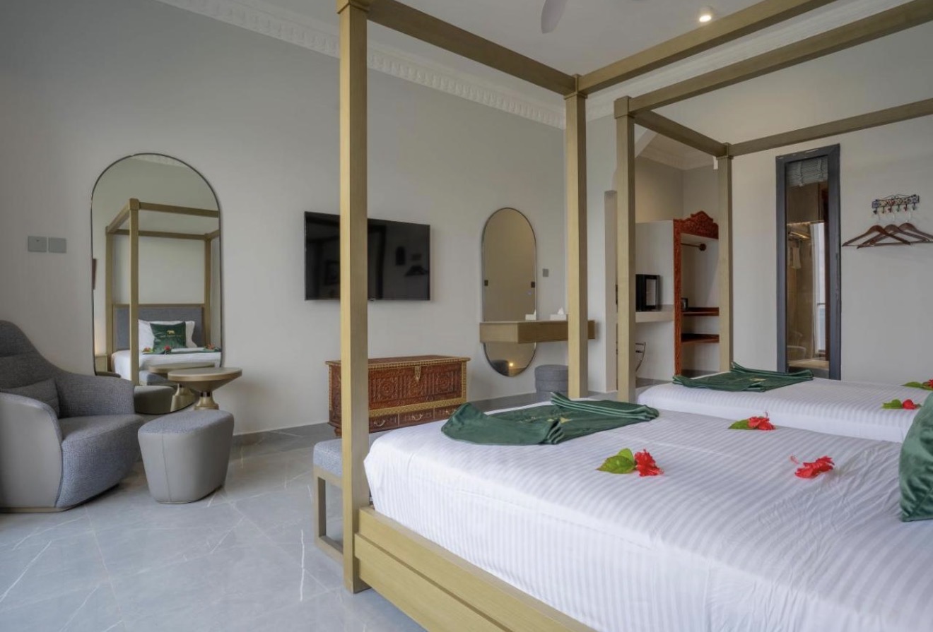 Room interior with gold four-poster bed, mirrors and carved chest